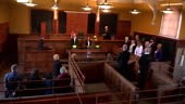 Stock 4K video clip footage of the Judge entering a full courtroom...