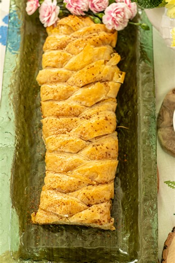 Make this Greek classic dessert into a phyllo braid. Crispy, golden layers wrapped around creamy semolina custard, then finished with a vanilla-lemon syrup. It looks bakery-fancy but I walk you through every step in the video. Perfect for holidays or any special dinner, and the recipe makes two braids. Want the recipe? Comment Recipe below and I’ll send it to you in Messenger. Or grab it here now: https://www.dimitrasdishes.com/galaktoboureko-phyllo-braid-greek-semolina-custard-in-phyllo/ | Dimi