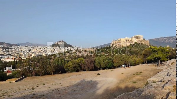 View of Pnyx Hill in Athens, Greece the historic gathering place of ancient democratic assemblies, with the majestic Parthenon and the iconic Lycabettus Hill rising gracefully in the background.