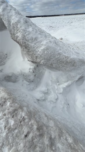 This Lake Ontario ice volcano is freshly-formed, yet already extinct. Very cold air and northerly winds over the last 24 funneled cold water through channels. At the end of the channel, the force and splash of the water gradually generated a mound of ice. With enough time, an ice volcano formed with water shooting through the top. This can only continue for so long, however. As temps got colder and winds lessened, the cold water itself froze up, stripping the volcano from its source for continue