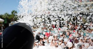 Foam party and black foam cannon with tourists in background. Entertainment for tourists