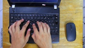 Hand of person typing on a laptop computer and using mouse