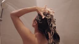 Woman washing hair with shampoo