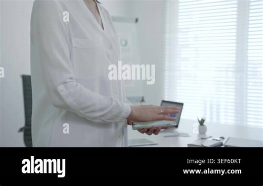 Professional business person using a mobile phone, hands interacting with the touchscreen, managing data and information while communicating wirelessly in an office environment Stock Video Footage - Alamy