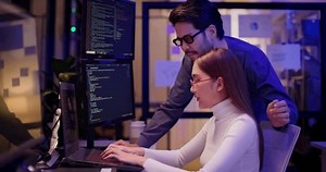 clip-3808595405-two-asian-software-engineers-collaborate-night-modern