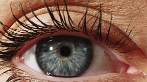 Grey Female Eye Close Up Extreme Macro Zoom 4K. Eyeball in opthalmology or optometry for eye exam or treatment zoom. Medical attendance at the optometrist in a bright modern clinic. Eye examination.