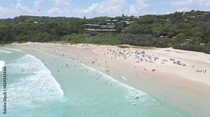 People Swim And Surf At Cylinder Beach - Campground Tents At Sandy Shore - Point Lookout, QLD, Australia. - aerial