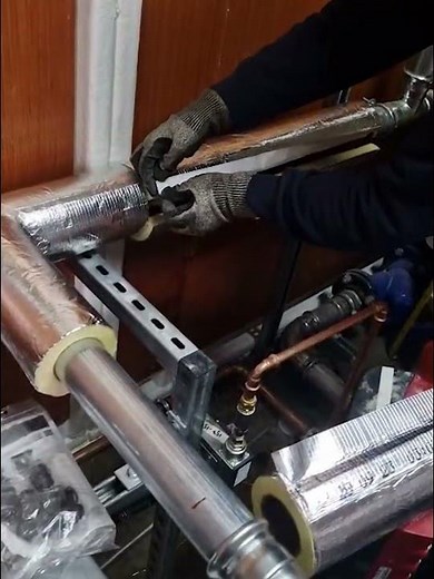 Insulating a straight piece of pipe with fibreglass pipe insulation.