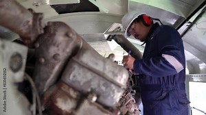 Industrial engineers,technicians,and supervisors inspecting and repairing machinery in the engine room,servicing and maintaining large locomotive engines,ensuring optimal performance and reliability i