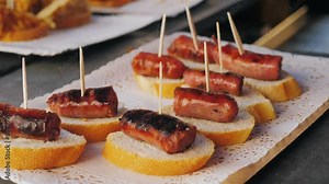Spanish tapas, pintxos, sandwich, basque cuisine, wine snack. Traditional medieval barbecue, catalan sausages, grill BBQ medieval style, fried meat food.