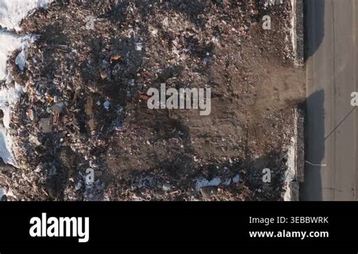 Top-down aerial view cows walk feed from dense domestic waste junkyard and landfill by car asphalt road. Vast expanse of discarded plastic, metal, and household trash piled in an outdoor disposal site Stock Video Footage - Alamy