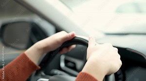 Close-up of hands gripping a steering wheel while driving. The driver maintains control and focus, showcasing the importance of safe driving practices