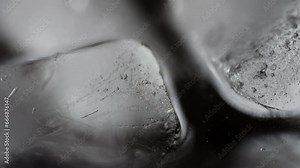 Close-up of a bubble passing through an ice cube: A fluid dynamics. The tiny bubble's journey through the translucent ice cube evokes an enchanting dance of light and clarity. High quality 4k footage