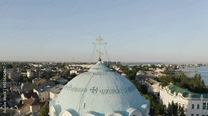 the Golden cross on the dome of the Cathedral towers over the city.
