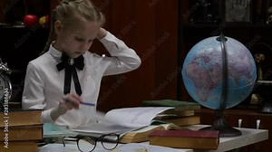 Schoolgirl doing homework, little blonde girl studing at home at the table. children's education. 4K