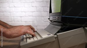 Hands typing on a vintage computer mechanical keyboard closeup.