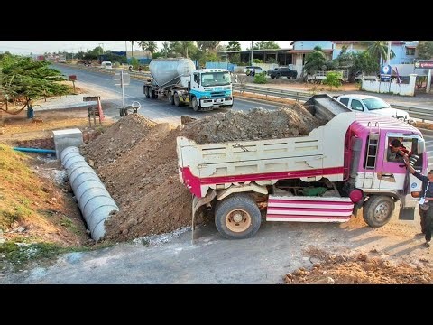 Dumping soil to bury the twin drainage next to the highway. Drivers passing by must be very careful.