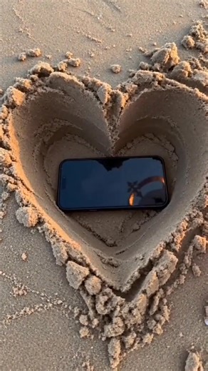 A dreamy sunset moment with Paimon from Genshin Impact 🌅 At the beach, under a golden sky, Paimon gently digs into the soft sand… creating a perfect heart shape. Inside that heart? A phone reflecting the warm sunset light — and Paimon herself smiling sweetly through it. Cute, wholesome, and aesthetic vibes all in one scene 💛 Like a tiny memory captured inside a heart of sand… #GenshinImpact #Paimon #Aesthetic #SunsetVibes | Pai Mon