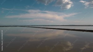 Alykes the Hellenic saltworks located outside of Mesolongi in Greece. Drone footage with the clouds reflection in the salt water.