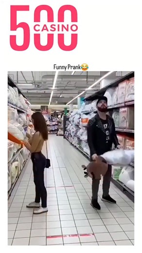 decode world on Instagram: "The post shares a 59-second video compilation of pranksters in a supermarket aisle striking unsuspecting shoppers—ranging from children to elderly—with soft toys, pillows, and balls, eliciting startled falls and reactions, overlaid with upbeat music and cartoon emojis for comedic effect. Despite 11,634 likes and 7.6 million views, the content draws sharp backlash in 181 replies, with users labeling it assault or harassment and warning of harm to those with conditions 