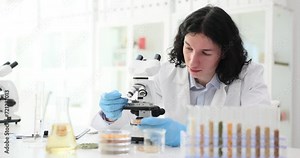 Scientist studies grains in laboratory looks through microscope. Grain quality analysis and laboratory work