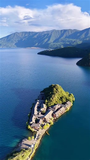 Lugu Lake — Lige Peninsula. The peninsula stretches into the deep blue waters of Lugu Lake, reflecting the surrounding green mountains. The stunning blend of lake and landscape creates a breathtaking view. 🚤🌄💙 #LuguLake #Lijiang #AerialPhotography | Amazing Yunnan