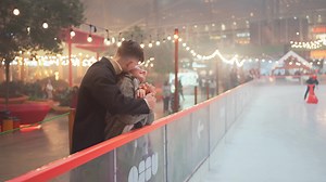 Happy romantic couple rubbing noses and kissing on illuminated street.