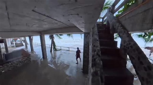 😱It takes a rare kind of person to willingly stand in the heart of chaos — and Storm Chaser Jordan Hall is one of them. As a powerful storm surge slammed into La Sunshine Beach Resort, waves roared over the second and third floors, crashing down the stairs with unrelenting force. At one point, Hall was nearly swept off his feet, clinging to the railing just in time — a chilling moment that perfectly captures both his courage and the raw power of nature. This educational video shows just how dan