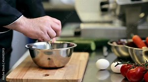 hands of male chef cook breaking egg in kitchen