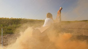 A Young father and his little son play together in the countryside. Dad rolls a happy child in a handmade cardboard plane on a dirt road, pyrotechnic smoke flies out from under the wings