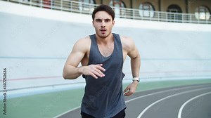 Male runner running at modern track. Sport man running on racetrack