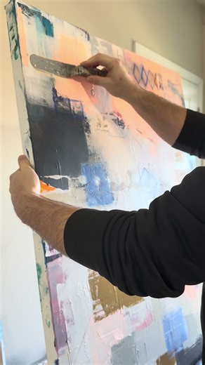 Final touches on an abstract, mixed media painting.
