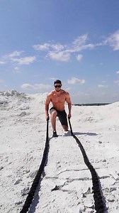 Man working out with fitness rope. Athletic muscular man doing workout with battle ropes Vertical