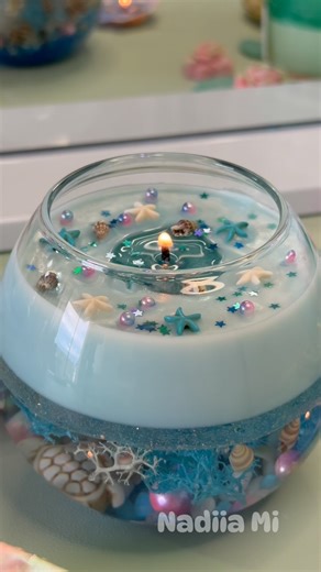 An ocean dream in a glass bowl — hand-poured water candle with seashells, starfish, shimmer and love. Tap for ASMR. Stay for the magic. Would you decorate your space with this? #candlemaking #candles #cozyvibes #diy #asmr #craft #trendingreels #madeincanada . . . . . . . . . . . . . water candle, ASMR DIY, cozy candle, ocean decor, aesthetic vibes, candle video, relaxing craft, handmade in Canada, home decor candle, beach-inspired, starfish candle, pastel wax art, satisfying content, calming DIY