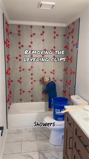 Brad Royce on Instagram: "Showers are tiled so I have Callen helping me break the leveling clips off so we can grout. #tips #tutorial #diy"