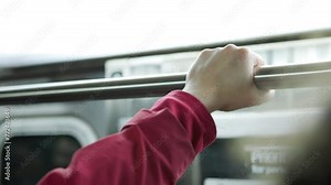 Female train rider holding rail on subway 4k