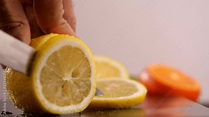 Knife cutting juicy lemon, Close-up slicing lemon in 4K resolution
