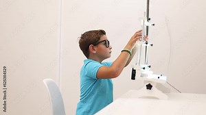 A child undergoes a convergence-divergence test using vectograms with polarized lenses.Vision therapy.