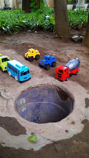 Big truck pushing yellow bus and car into pit