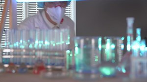 Scientist mixing components on flasks - Free Stock Video