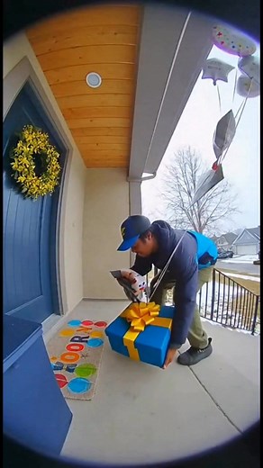 At 1:22 PM a delivery driver walked up to a front doorstep holding a bright gift box covered in cartoon stickers and ribbons. He set it down gently, knocked on the door, and stepped back with a smile. A little boy opened the door a few seconds later, confused at first…until he saw his name written on the box. His whole face lit up instantly. He tore the lid open and let out the biggest smile, jumping up and down with pure birthday excitement. The driver watched from the walkway, happy to be part