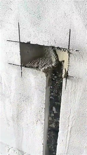 Cutting out a rectangular section in a concrete wall using a trowel for electrical box installation