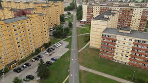 Chernobyl style old building. Aerial view over soviet architecture. Block of flats in the row. Soviet style architecture. Long pave walkway. Cars parked next to the building. Old Russian buildings.