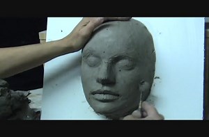 Sculpting a female face in clay.