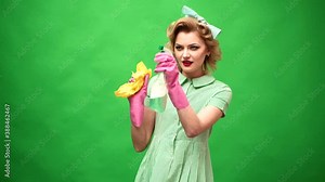 Funny housekeeper. Housekeeping and cleaning concept. Wife with clean spray, duster. Cleaning, retro style, purity. Cleanup, cleaning services. Retro woman cleaner on green background.