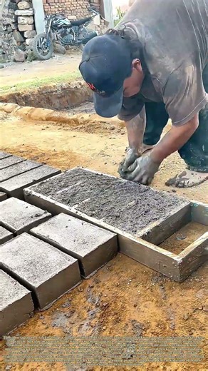 Shaping the Blocks: How a Worker Uses a Wooden Mold to Hand-Craft Cement Bricks