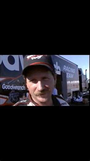 November 1990 at Atlanta Motor Speedway — one race left in the NASCAR Winston Cup season. Dale Earnhardt is on the verge of securing his fourth Cup championship, battling through one of the tightest title fights of the era. With the pressure at its peak, Earnhardt grabs the official race program and playfully tells sportscaster Jim Celania that the cover photo of him doesn’t look happy enough — that he could’ve smiled more. A quick moment of levity in a high-stakes championship setting. That bal