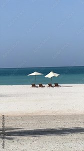 Romantic escape featuring beach beds beneath beach umbrella set against shimmering turquoise sea Coastal paradise offers perfect setting for romantic getaway where couples can relax enjoy