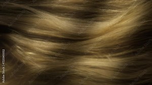 Beauty and glamour hair blowing in the wind in slow motion. Healthy shiny hairs. Hair restoration or care and barbershop or hairdressing concept. Glowing hair macro vertical background