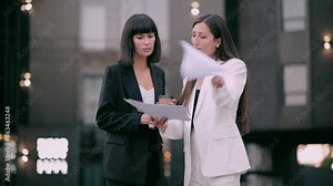 The boss scolds his subordinate. An angry female boss argues with a subordinate employee about documents. Two business women are arguing on the street.